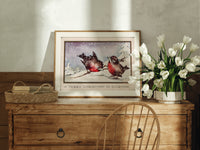 Two red robins on branch print in an oak frame on a farmhouse dresser beside white tulips