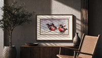 Two red robins on branch print in a wood frame above a fluted sideboard beside an olive tree