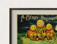Close-up of the Anthropomorphic pumpkin heads with girl print's dark wood frame corner and archival matte paper
