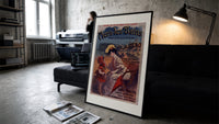 Woman and child at beach print in a slim black frame leaning on a dark sofa in a concrete print studio