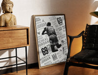Brass-framed Michael Jordan slam dunk print leaning in a warm styled corner by a sculpture