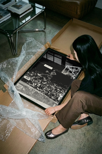 Woman opening a Michael Jordan free throw dunk poster from a crush-resistant brown shipping tube