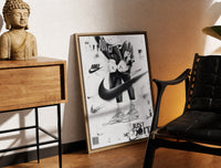 Brass-framed KAWS figure wearing Air Jordan sneakers print leaning in a warm styled corner by a sculpture
