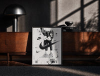 Black-framed KAWS figure wearing Air Jordan sneakers print on a moody console with designer coffee-table books