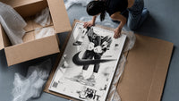 KAWS figure wearing Air Jordan sneakers framed print being unpacked from protective bubble wrap and a box