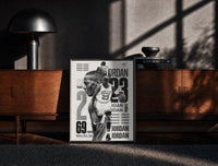 Black-framed Michael Jordan basketball player print on a moody console with designer coffee-table books