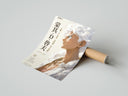 Rolled White-haired smiling anime man profile poster beside its crush-resistant kraft shipping tube