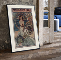 Art Nouveau woman with flowers print in a black frame leaning beside a vintage door on parquet