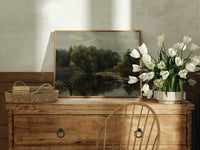 Tranquil pond with lily pads print in an oak frame on a farmhouse dresser beside white tulips