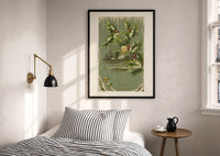 Church A Merry Christmas print in a black frame above a bed with striped linens, a brass wall lamp and a sunlit window
