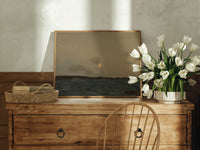 Moon rising over coastal sea print in an oak frame on a farmhouse dresser beside white tulips