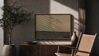 Moon rising over coastal sea print in a wood frame above a fluted sideboard beside an olive tree