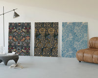 William Morris floral bird patterns three-panel set displayed beside a brown leather sofa