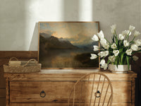 Mountain lake at sunset print in an oak frame on a farmhouse dresser beside white tulips