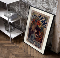 Woman drinking beer with poppies poster in a black frame leaning beside a shelf in a raw-plaster loft