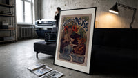 Woman drinking beer with poppies print in a slim black frame leaning on a dark sofa in a concrete print studio