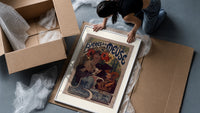 Woman drinking beer with poppies framed print being unpacked from protective bubble wrap and a box