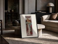 Woman holding champagne glass print in a black frame leaning on a travertine table in a sunlit lounge