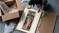 Woman holding champagne glass framed print being unpacked from protective bubble wrap and a box