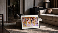 Four women representing the four seasons print in a slim black frame leaning on a travertine coffee table