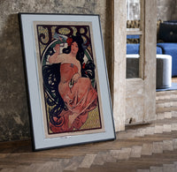 Woman with flowing dark hair smoking print in a black frame leaning beside a vintage door on parquet