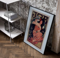 Woman with flowing dark hair smoking poster in a black frame leaning beside a shelf in a raw-plaster loft
