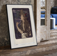 Woman with flowing hair smoking print in a black frame leaning beside a vintage door on parquet