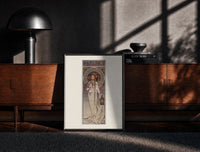 Black-framed Art Nouveau woman with flowers print on a moody console with designer coffee-table books