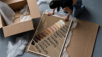 Nail Swatches in Brown Tones framed print being unpacked from protective bubble wrap and a box
