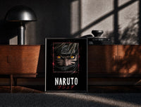 Black-framed Naruto Uzumaki close-up face print on a moody console with designer coffee-table books