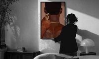 Neckline Trim with Clippers print in a slim black frame being hung on a sunlit wall in a monochrome room
