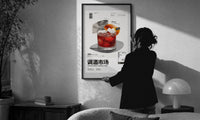 Negroni Cocktail Market print in a slim black frame being hung on a sunlit wall in a monochrome room