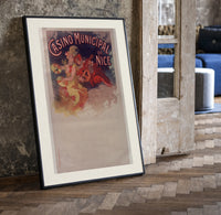 Woman with cymbals and mandolin player print in a black frame leaning beside a vintage door on parquet