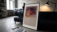 Woman with cymbals and mandolin player print in a slim black frame leaning on a dark sofa in a concrete print studio