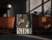 Black-framed Nike Air Force 1 Low on Brown print on the floor in front of a dark wooden console