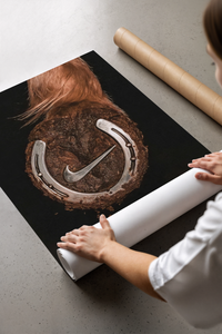 Surreal sneaker poster leaning beside a cardboard tube showing a silver horseshoe in a brown hoof