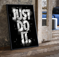 Just Do It typography design print in a black frame leaning beside a vintage door on parquet