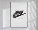 Blurred Nike swoosh logo poster in a slim frame on a bright wall with soft window light