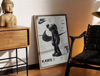 Brass-framed KAWS Companion figure standing print leaning in a warm styled corner by a sculpture