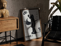 Walnut-framed KAWS Companion figure standing print leaning against a sunlit rustic brick wall