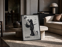 KAWS Companion figure standing print in a black frame leaning on a travertine table in a sunlit lounge