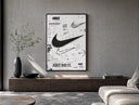 Nike Swoosh logo design study poster framed above a wood console in a concrete-wall living room