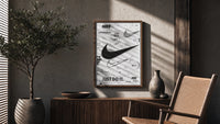 Nike Swoosh logo design study poster framed above a fluted sideboard beside an olive tree