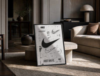 Nike Swoosh logo design study print in a black frame leaning on a travertine table in a sunlit lounge