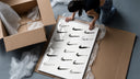 Various hand-drawn Nike swoosh logos framed print being unpacked from protective bubble wrap and a box
