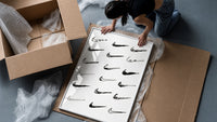 Various hand-drawn Nike swoosh logos framed print being unpacked from protective bubble wrap and a box