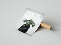 Rolled Monstera plant in Nike garbage bag poster beside its crush-resistant kraft shipping tube