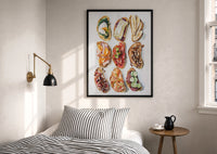 Nine Crostini Grid print in a black frame above a bed with striped linens, a brass wall lamp and a sunlit window
