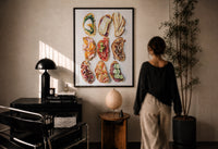 Nine Crostini Grid print in a black frame on a sunlit plaster wall, a woman looking on beside a mushroom lamp