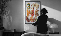 Nine Crostini Grid print in a slim black frame being hung on a sunlit wall in a monochrome room